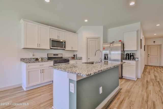 7406 9th St, Lubbock, TX 79416 - kitchen featuring appliances with stainless steel finishes, a sink, light wood finished floors, white cabinetry, and recessed lighting