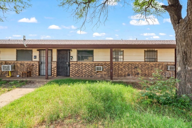 ranch-style home featuring an AC wall unit