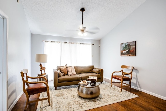 living room featuring dark wood-type flooring, ceiling fan, lofted ceiling, and a textured ceiling