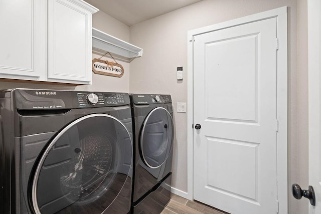 clothes washing area featuring cabinets, independent washer and dryer, and light hardwood / wood-style floors