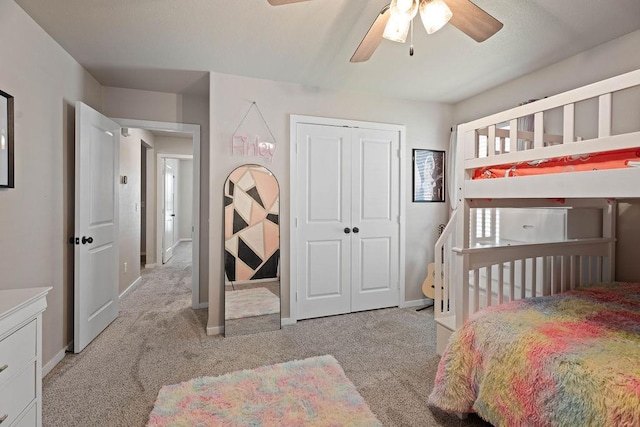 carpeted bedroom with ceiling fan and a closet