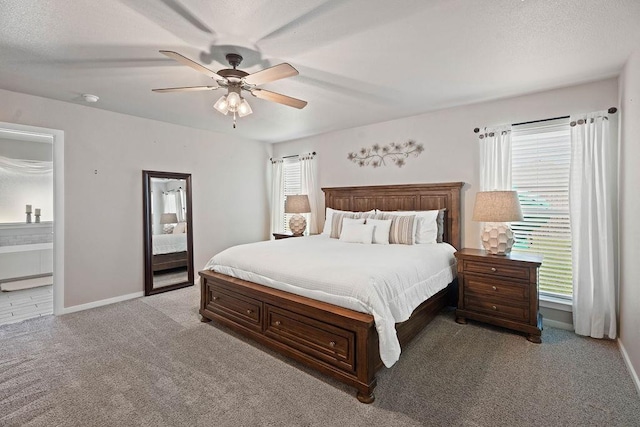 carpeted bedroom featuring ceiling fan, connected bathroom, and a textured ceiling