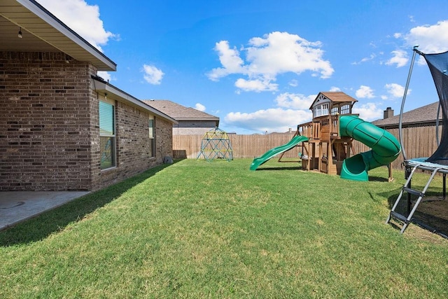 view of yard featuring a trampoline and a playground