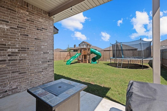 view of yard featuring a patio, a playground, and a trampoline