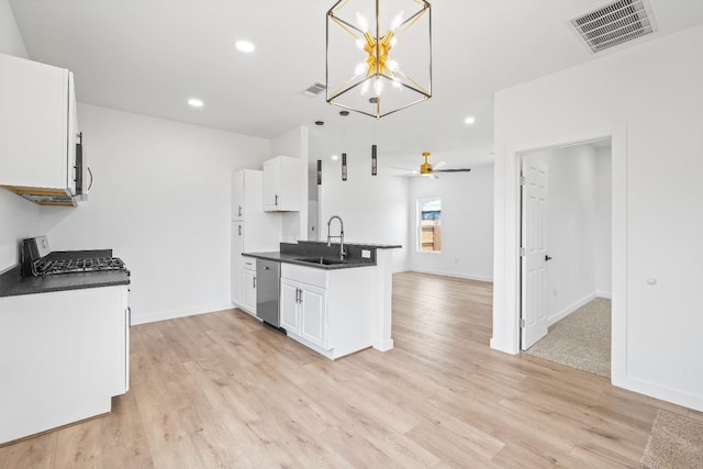 kitchen featuring sink, white cabinetry, hanging light fixtures, stainless steel appliances, and light wood-type flooring