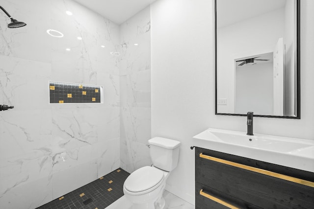 bathroom with vanity, toilet, and a tile shower