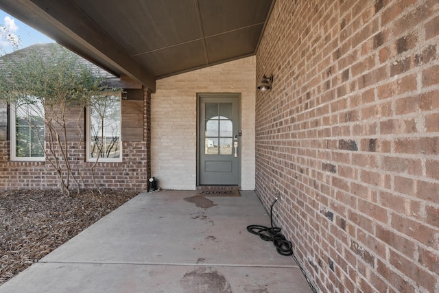 view of exterior entry with a patio