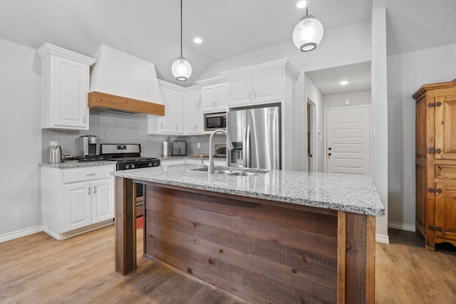 kitchen with hanging light fixtures, stainless steel appliances, custom range hood, and white cabinets