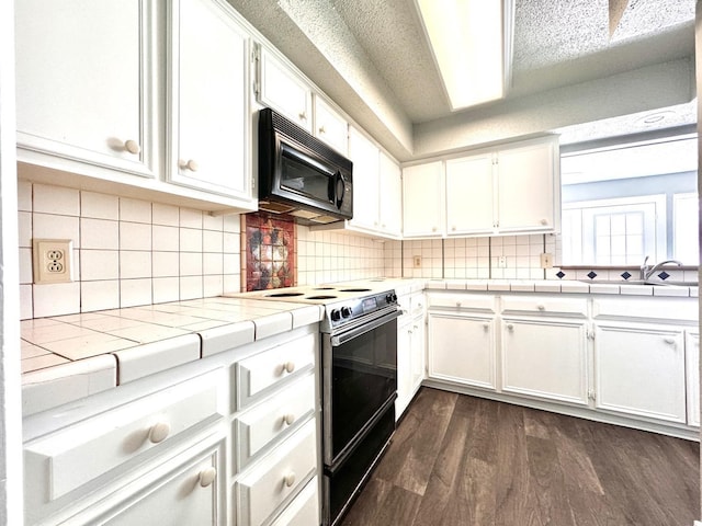 kitchen with white cabinetry, electric range oven, tile counters, and dark hardwood / wood-style floors