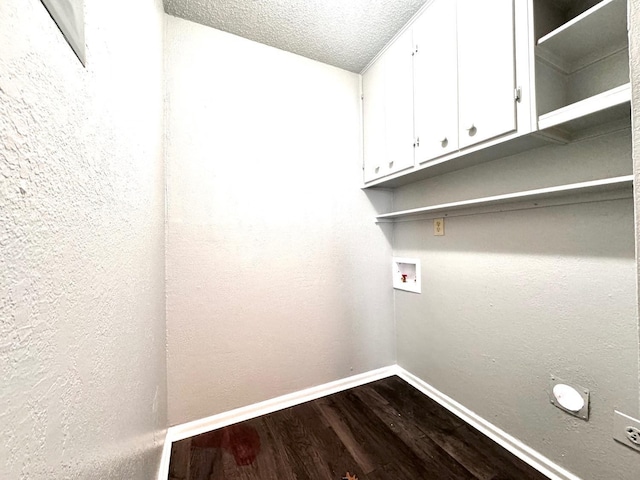 laundry area with washer hookup, wood-type flooring, cabinets, and a textured ceiling