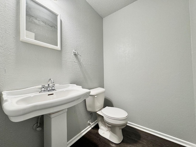 bathroom featuring wood-type flooring and toilet