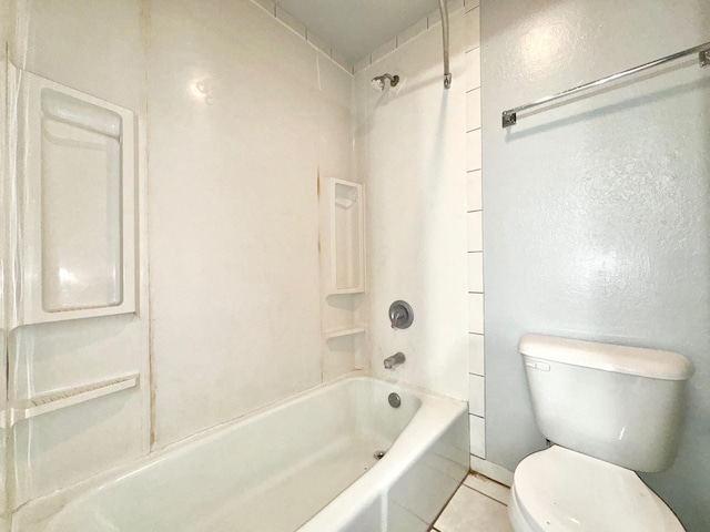 bathroom with tile patterned flooring, washtub / shower combination, and toilet