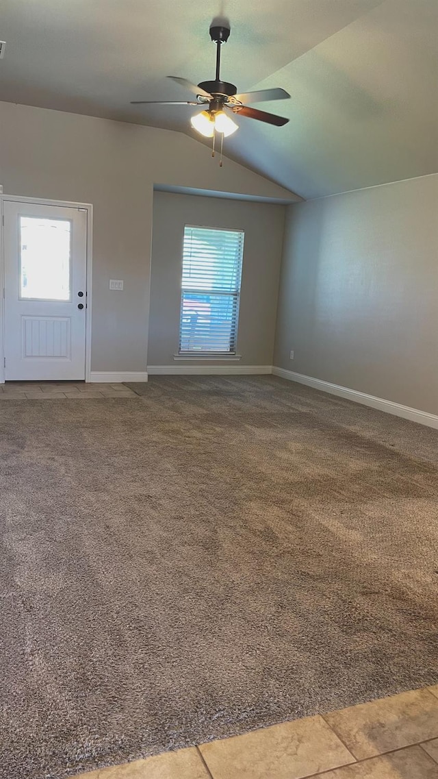 carpeted empty room featuring vaulted ceiling and ceiling fan