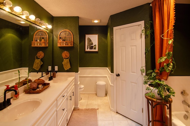 bathroom featuring a bath, double vanity, a sink, and tile patterned floors