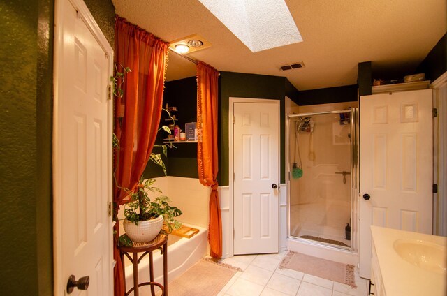 full bathroom with visible vents, a stall shower, a bath, tile patterned flooring, and a skylight