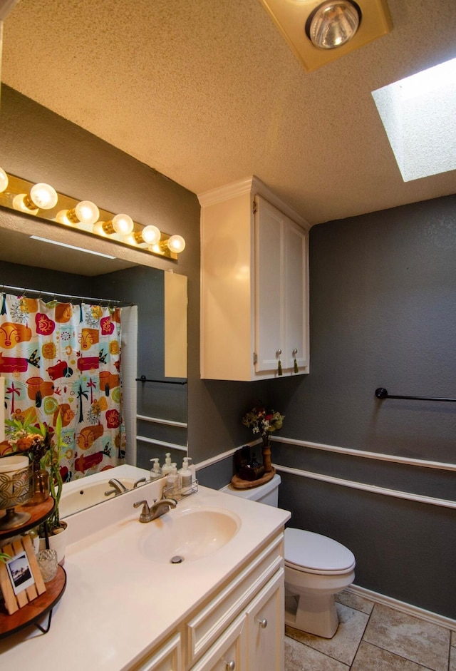 full bath featuring vanity, curtained shower, toilet, a textured ceiling, and a skylight