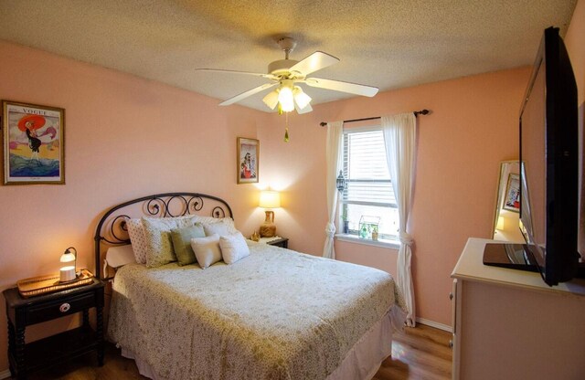 bedroom featuring a textured ceiling, wood finished floors, ceiling fan, and baseboards