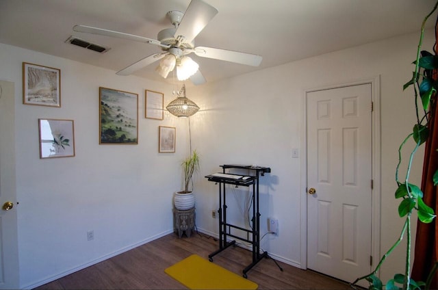 exercise room featuring wood finished floors, visible vents, ceiling fan, and baseboards