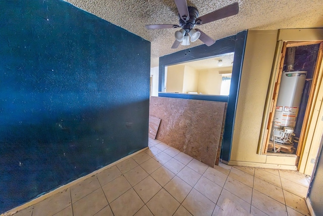 unfurnished room featuring light tile patterned floors, a textured ceiling, water heater, and ceiling fan