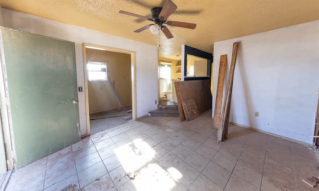 interior space with ceiling fan and a textured ceiling