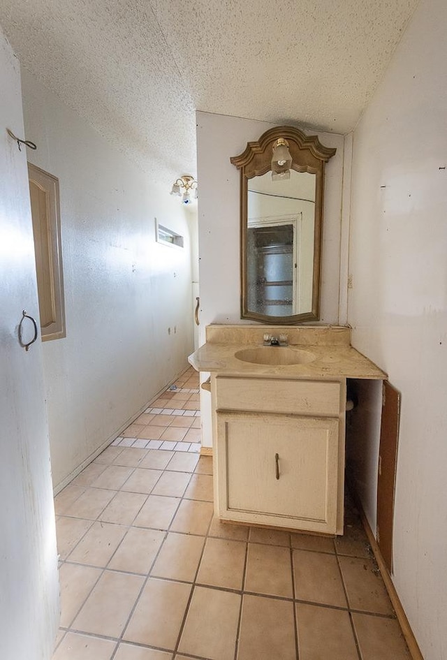 bathroom with tile patterned flooring, vanity, and a textured ceiling