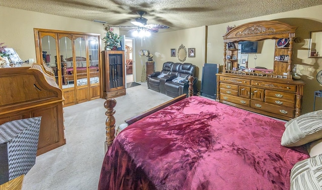 carpeted bedroom with ceiling fan, a closet, and a textured ceiling