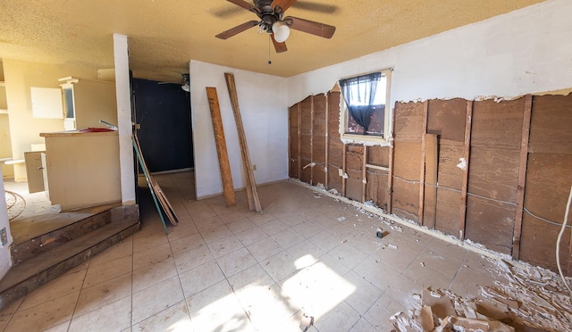 interior space with a textured ceiling and ceiling fan