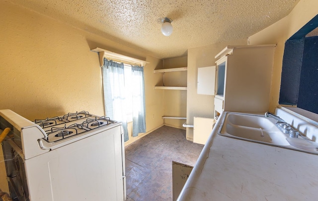 kitchen with sink, white gas range oven, and a textured ceiling