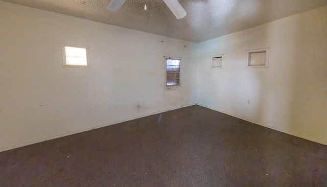 empty room with ceiling fan and a textured ceiling