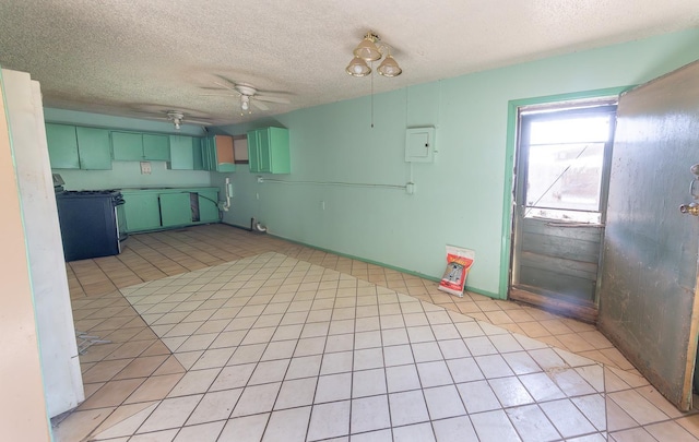 kitchen with light tile patterned flooring, electric panel, ceiling fan, gas stove, and a textured ceiling