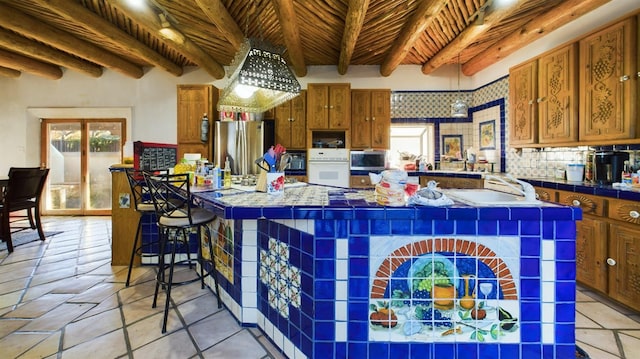 kitchen with wood ceiling, a breakfast bar, appliances with stainless steel finishes, beam ceiling, and a center island