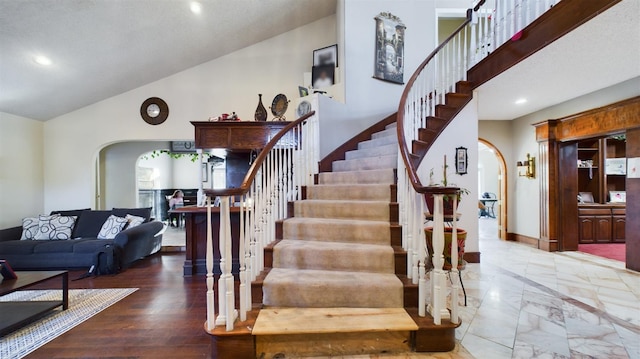 staircase with high vaulted ceiling