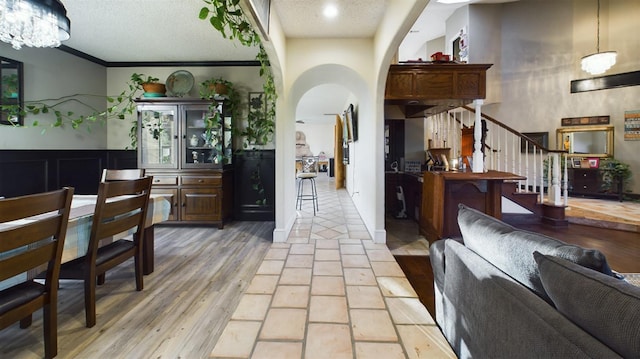 living room with crown molding, light hardwood / wood-style flooring, and a textured ceiling