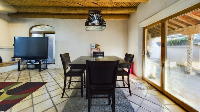 tiled dining space featuring wood ceiling and beamed ceiling