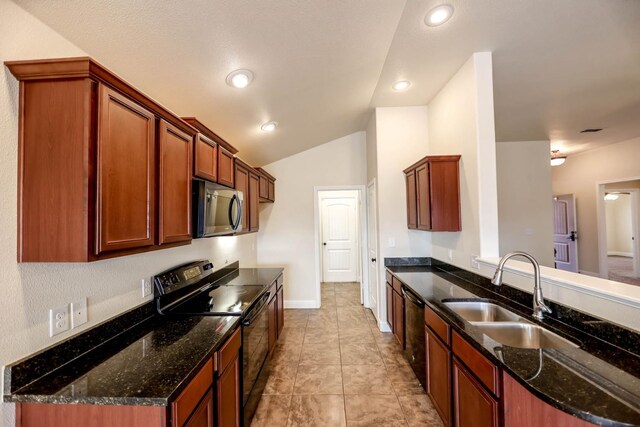 kitchen featuring black appliances, lofted ceiling, sink, dark stone countertops, and kitchen peninsula