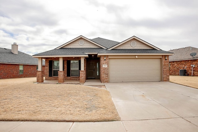 view of front facade featuring cooling unit, a garage, and covered porch