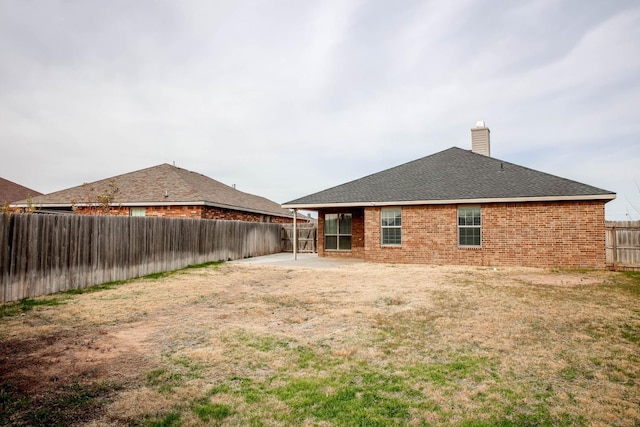 rear view of house with a lawn and a patio area