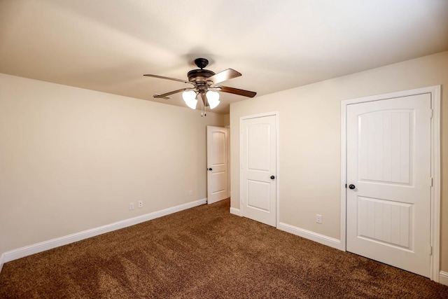 unfurnished bedroom with ceiling fan and dark colored carpet