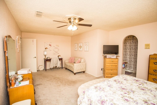 bedroom featuring ceiling fan, carpet flooring, and a textured ceiling