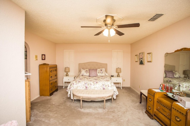 carpeted bedroom with a textured ceiling and ceiling fan