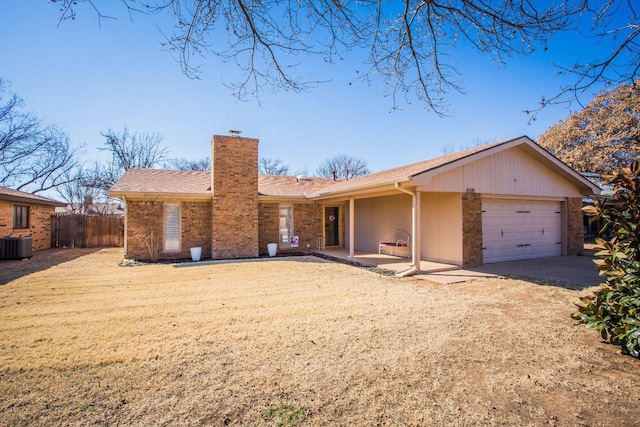 ranch-style home with central AC unit and a garage