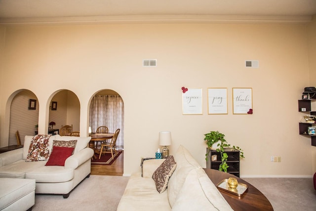 living room with crown molding and light colored carpet