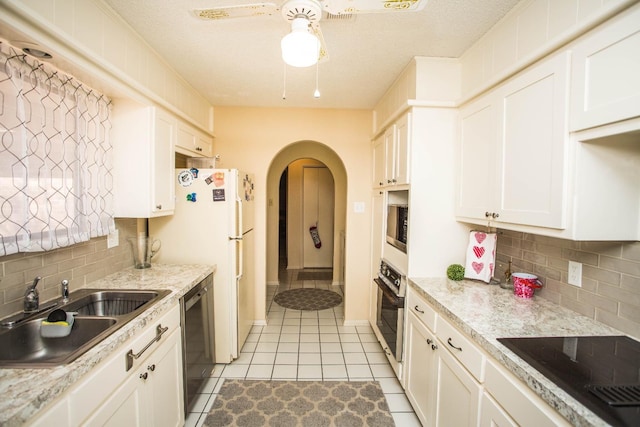 kitchen with light tile patterned flooring, sink, white cabinetry, decorative backsplash, and black appliances