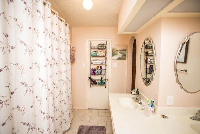 bathroom featuring tile patterned flooring, vanity, curtained shower, and a textured ceiling