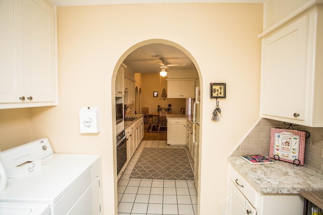 laundry room with cabinets, light tile patterned floors, washer and dryer, and ceiling fan