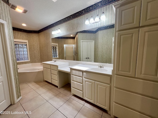 9802 Toledo Ave, Lubbock, TX 79424 - bathroom featuring wallpapered walls, tile patterned flooring, a garden tub, two vanities, and a textured ceiling