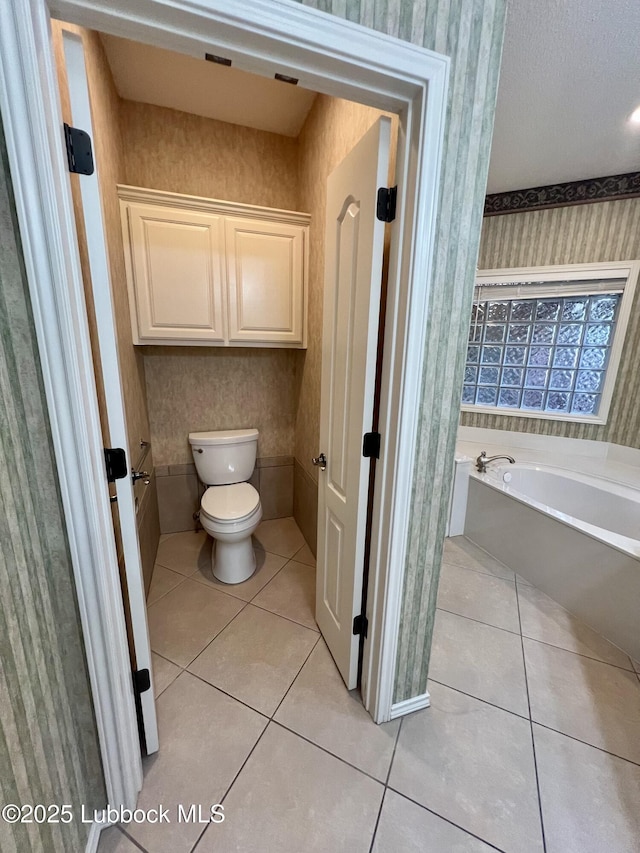 9802 Toledo Ave, Lubbock, TX 79424 - bathroom with wallpapered walls, tile patterned floors, and a bath
