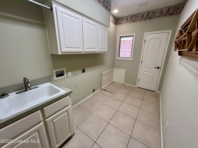 9802 Toledo Ave, Lubbock, TX 79424 - laundry area featuring electric dryer hookup, cabinet space, hookup for a washing machine, and light tile patterned flooring