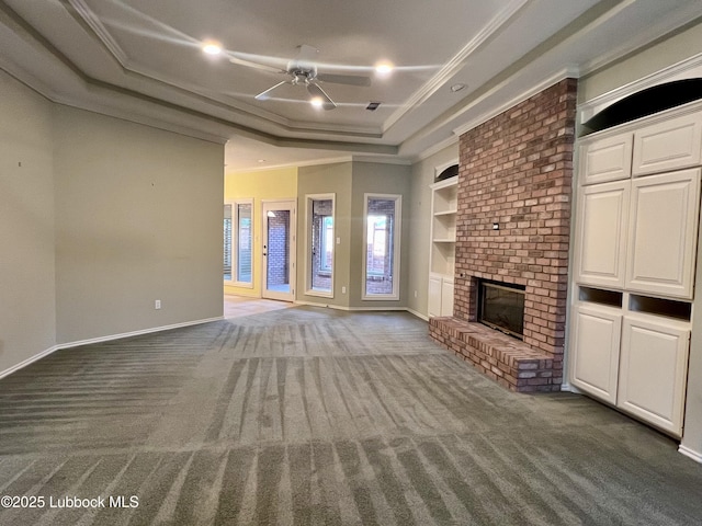 9802 Toledo Ave, Lubbock, TX 79424 - unfurnished living room featuring carpet, a ceiling fan, a tray ceiling, a fireplace, and ornamental molding