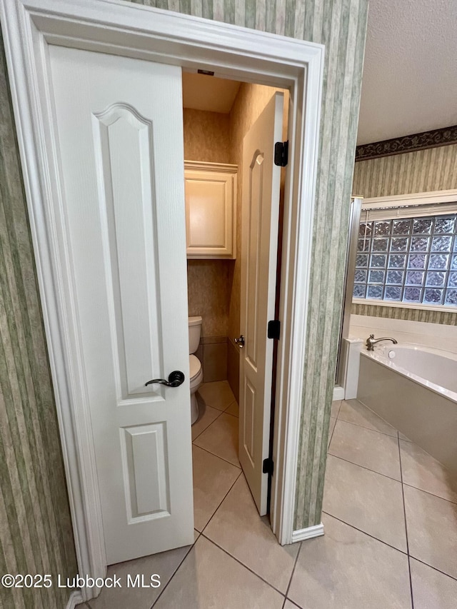 9802 Toledo Ave, Lubbock, TX 79424 - bathroom featuring tile patterned flooring, wallpapered walls, and a garden tub